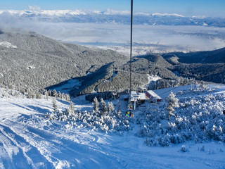 Bansko, Bulgaria - January 2017: Winter ski resort Bansko with ski slope, lift cabins, people and...