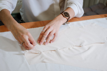 dressmaker sewing dress fabric with hand. Fashion designer tailor or sewer in workshop studio designing new clothes