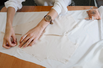 Obraz premium dressmaker sewing dress fabric with hand. Fashion designer tailor or sewer in workshop studio designing new clothes