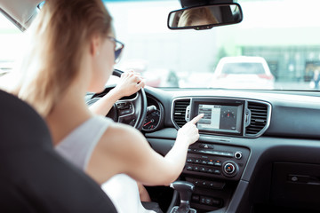 woman driving car, choosing navigation on monitor screen, presses touch menu, navigation map, route...