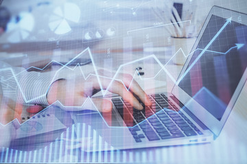 Multi exposure of stock market graph with man working on laptop on background. Concept of financial analysis.