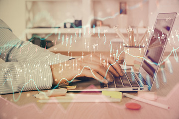 Double exposure of stock market graph with man working on laptop on background. Concept of financial analysis.