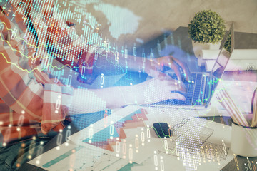 Double exposure of stock graph with businessman typing on computer in office on background. Concept of hard work.