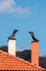 two modern brick chimneys with wind cone on the roofs
