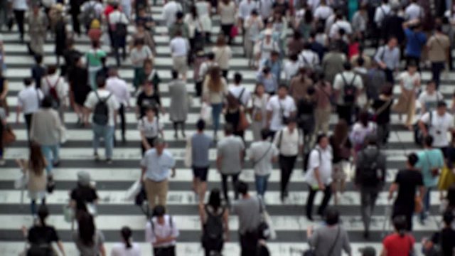 UMEDA, OSAKA, JAPAN - CIRCA SEPTEMBER 2019 : Aerial blurred high angle view of zebra crossing near Osaka train station. Crowd of people at the street. Shot in busy rush hour. Wide slow motion.
