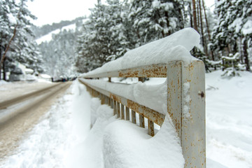 metal fence in the snow, road to a ski resort