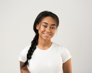 Portrait of african-american girl posing over grey background