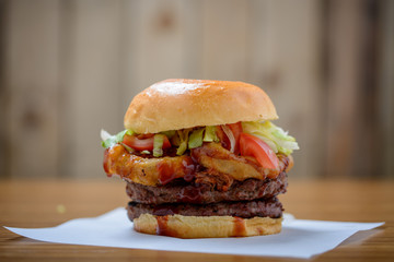 Double stack beef burger with onion rings, salad and bbq sauce