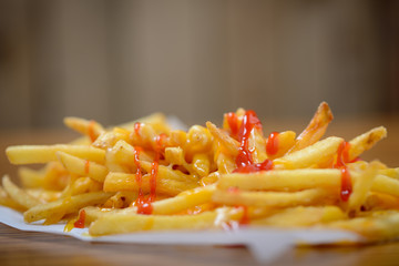 French fries with cheese and ketchup close up with copy space above