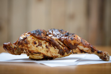 Half a grilled jerk chicken on table with copy space