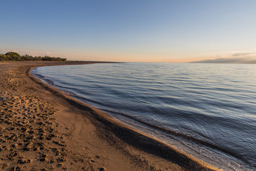 Issyk kul lake with mountains on background in Kyrgyzstan, near Karakol village