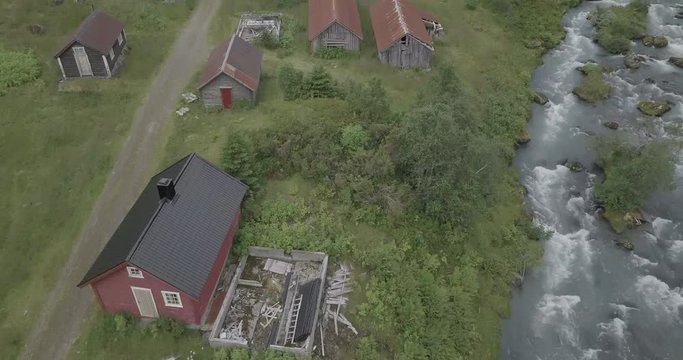 Red small house in the mountains 4k drone view of Norwegian houses and Briksdal, Briksdalsbreen glacier aerial shot colorful, river