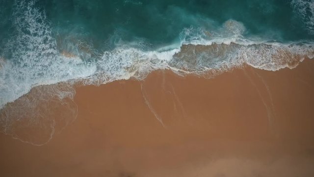 Aerial view waves break on white sand beach. Sea waves on the beautiful beach aerial view drone
