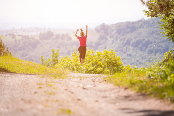 young woman jogging on sunny day at nature