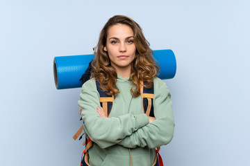 Young blonde hiker girl over isolated blue background