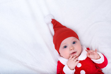 Portrait of cute little girl in a santa hat and costume. Christmas concept. Copy space. White background.