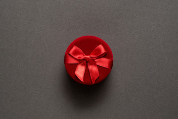 Round red closed jewelry box on a black background. Top view