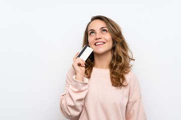 Fototapeta premium Young blonde woman holding a credit card