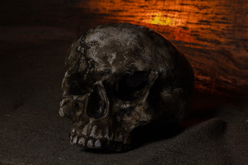 Human Skull with red light on brown textile background , Halloween decorations concept