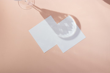square business card mockup on pink background with wineglass shadows and reflection