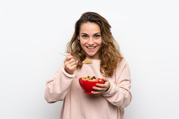Young blonde woman holding a bowl of cereals