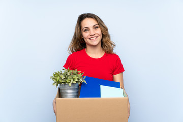 Young blonde woman holding a box to move it to another site