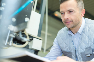 printing press worker operating machine