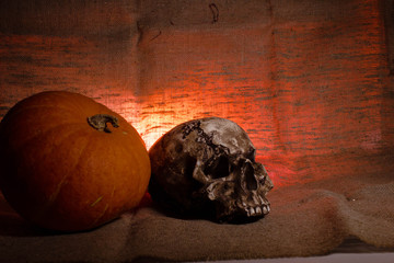 Human Skull with red light on brown textile background , Halloween decorations concept