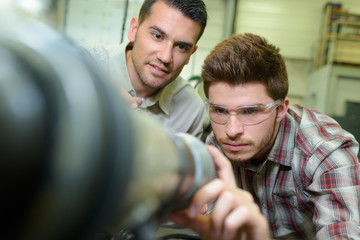 trainee adjusting equipment under his supervisors guidance