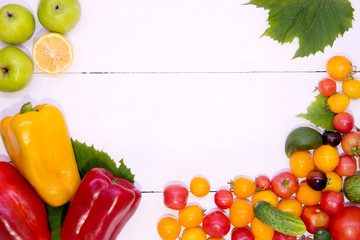 Background with vegetables. Vegetables on a white background wood texture top view. Tomatoes cucumbers peppers apples. Proper nutrition and diet. Concept of vegetarianism and detox.