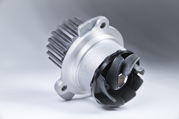New metal automobile pump for cooling an engine water pump on a gray background with a gradient....