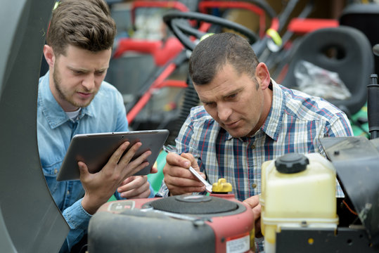 young mechanical supervisor inspecting senior apprentice work