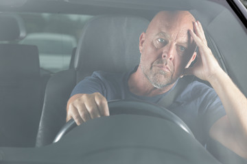 man in his car with hands on head during traffic-jam - Powered by Adobe