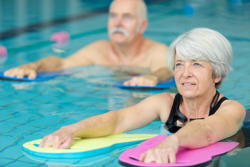 senior woman learning to swim in a pool