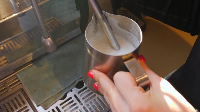 Coffee machine working barist heat and shake a milk for cappuccino