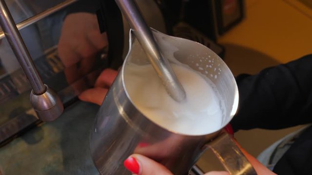 Coffee machine working barist heat and shake a milk for cappuccino
