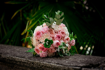 a small, beautiful girl in bright clothes,and in an orange hat, dancing near a Christmas tree, with a Christmas bouquet in her hand