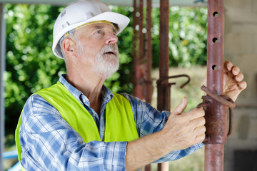 senior male worker during installation of gutter system