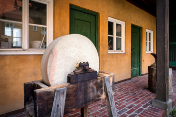 Ancient grinding wheel in front of a house