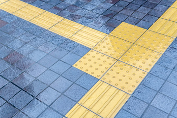 雨に濡れた点字ブロック