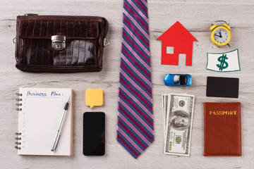 Businessman flatlay on wooden surface. Tie, different personal and office stuff. Usual things around person.