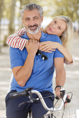 Fototapeta premium portrait happy couple elderly using a bike in park