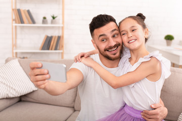 Happy father and child making selfie on cellphone