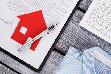Signed contract, paper house and pen. Successful realtor's deal. Investment in realty.