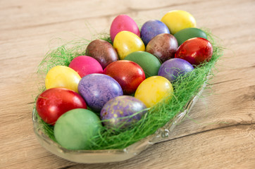Obraz na płótnie Canvas Easter eggs in basket on wooden background