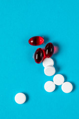 pharmaceutical medicine pills, tablets and bottle on blue background. Copy space for text