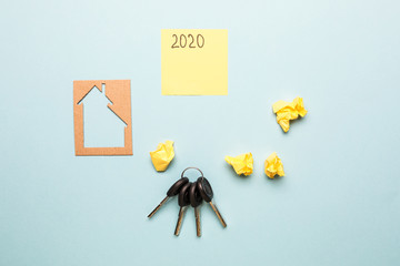 buy house online with paper figures, keys and card on office desk blue background