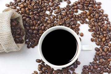 cup of coffee with beans on white background