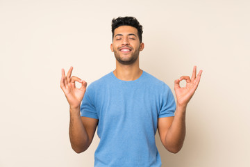 Young handsome man over isolated background in zen pose