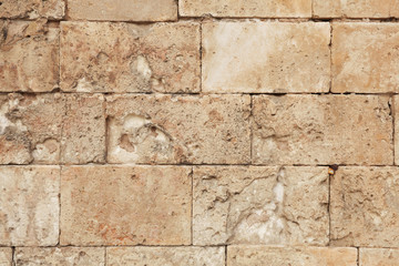 Old and weathered large stone blocks wall texture. Beige sandstone tones